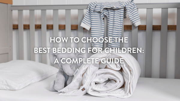 Rolled up children's duvet and cuddly grey elephant on a children's mattress in a cot